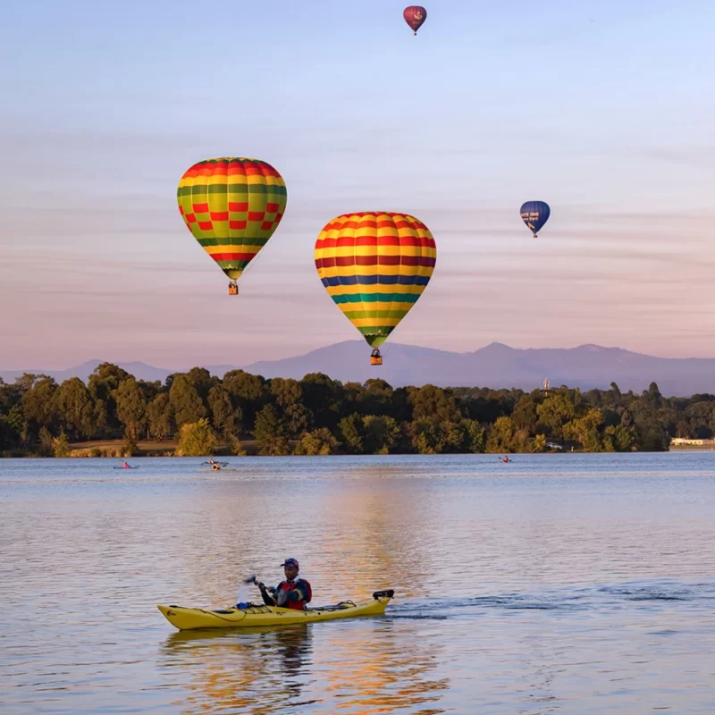 Floating hot air balloons over a lake in Canberra