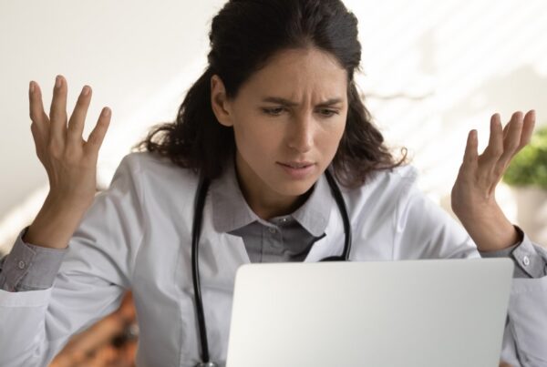 woman at her computer looking into how Payroll Tax works for GPs in each Australian state
