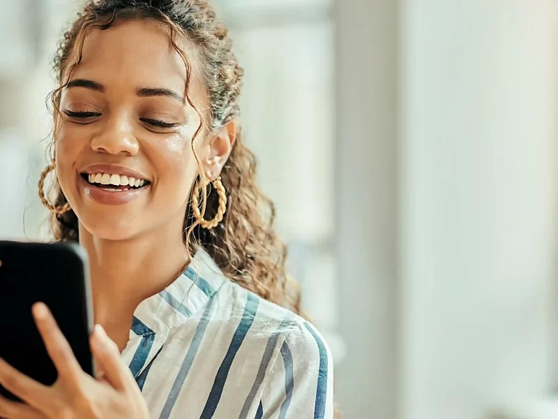 smiling young woman looking at phone
